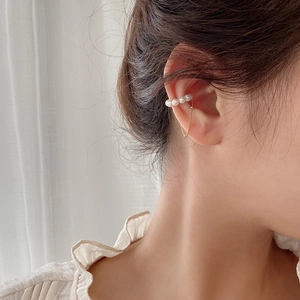 Detail of 925 silver shell pearl ear cuff with long gold tassel on a female model