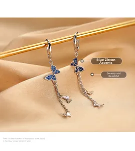 Boucles d'oreilles papillon avec zircons bleus et glands sur soie couleur champagne