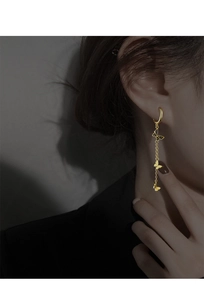 Gros plan de boucles d'oreilles papillon dorées avec zircons noirs sur un mannequin