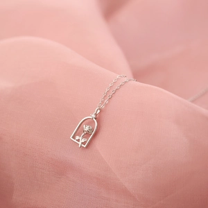 Detailed close-up of 925 silver rose flower necklace with elegant bell-shaped pendant frame