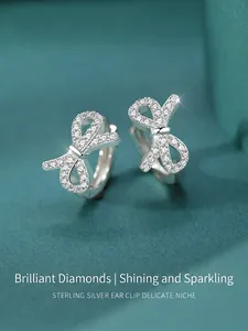 Gros plan de boucles d'oreilles nœud en argent S925 avec zircons sur velours vert