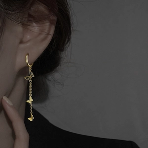Boucles d'oreilles papillon dorées avec pompons et détails en cristaux noirs pavés