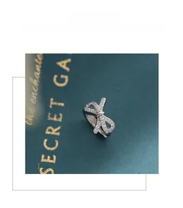 Vue détaillée des boucles d'oreilles nœud en argent S925 avec zircons coupe cœur et flèche