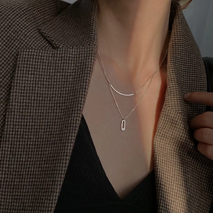 Macro view of double-layer silver necklace featuring geometric pendant and zircon inlay