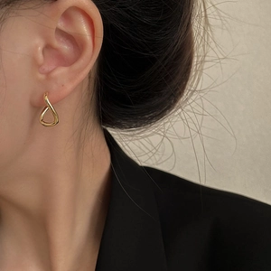Close-up of elegant gold irregular twisted earrings on model with a minimalist design