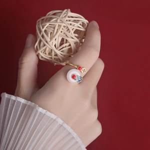 S925 silver Chinese cloud ring with white jade and red beads on a red backdrop
