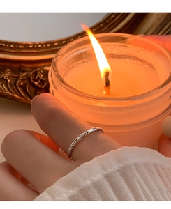 Close-up of S925 sterling silver Mobius ring with Luck lettering in warm candle light