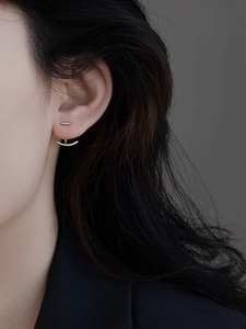 Gros plan d'une boucle d'oreille Ear Jacket en argent minimaliste sur modèle