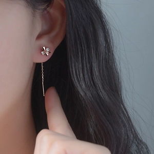 Rose gold s925 silver four-leaf clover tassel earrings worn by a model for an elegant look