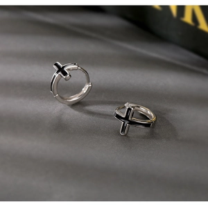 Créoles en argent sterling S925 avec pendentifs croix noirs sur fond gris texturé