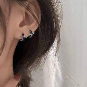 Créoles en argent S925 avec pendentif croix en émail noir portées par une femme