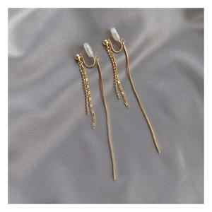 Detail of golden long tassel clip-on earrings with comfortable white silicone pads