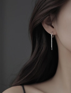 Detail of silver knot stud with long cascading chain tassels on female model
