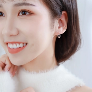 Bamboo style silver hoop earrings for women shown as a close-up on a model