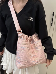 Pink drawstring tote bag with colorful embroidery and wide adjustable shoulder strap