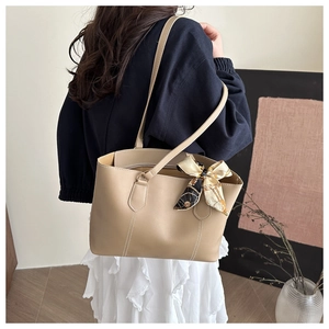 Chic beige leather shoulder bag featuring a geometric silk scarf on the handle strap