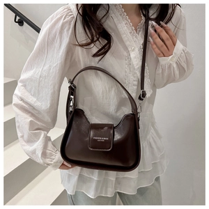 Side view of dark brown leather underarm bag with white fashion text and silver buckle