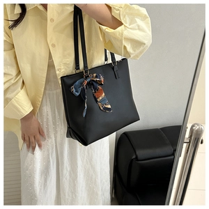 Detail der schwarzen Shopper-Tasche aus Kunstleder mit gemustertem Seidentuch am Griff