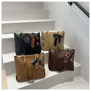 Details von vier Retro-Tragetaschen in Schwarz, Beige, Camel und Dunkelbraun mit Seidentüchern