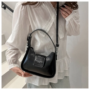 Detail view of the black crescent underarm bag with adjustable strap and leather texture