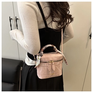 Detail of light pink marble-patterned handbag with silk scarf handle and gold hardware