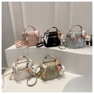 Set of five mini crossbody box bags in various colors with silk scarf handles and pompoms