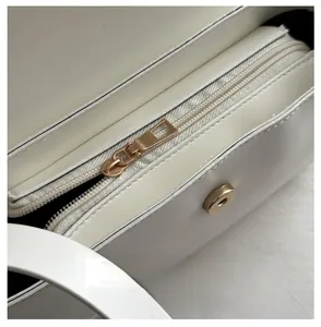 Macro detail of high-quality metal zipper and magnetic closure on minimalist white leather bag