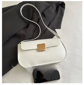 White faux leather baguette bag with gold buckle detail shown against a black blazer