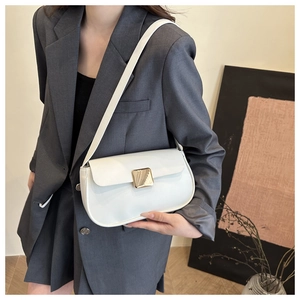Detail view of white leather underarm bag with gold square buckle on grey suit model