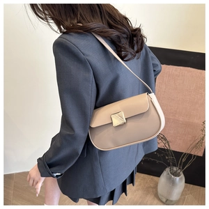 Detail of minimalist beige crossbody bag with premium gold square buckle on leather flap
