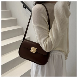 Close-up of a chocolate brown leather shoulder bag with a square gold metallic buckle