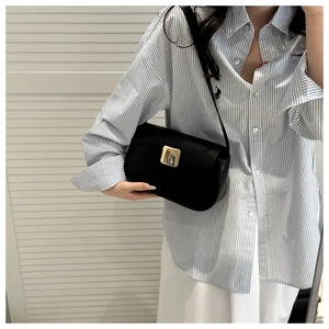 Classic black leather crescent bag with large gold square buckle shown on model