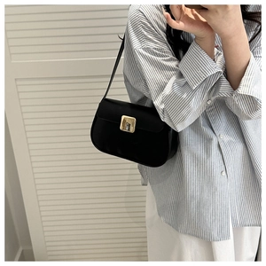 Détail du sac à bandoulière noir minimaliste avec son fermoir carré en métal doré chic