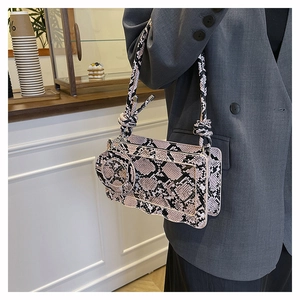 Detail of pink and black snake pattern handbag with knotted strap and round coin purse