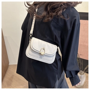 Detail view of a white vintage square bag with a golden horseshoe buckle on a model