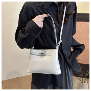 Detail of white glossy Kelly style shoulder bag with silver twist lock on black shirt