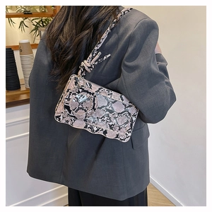 Detail der pinken Schlangenmuster-Tasche mit Wellenboden-Design und geknotetem Trageriemen