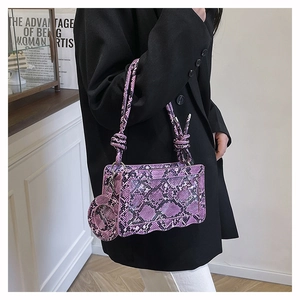 Détail du sac bandoulière violet effet serpent avec base ondulée et lanières nouées