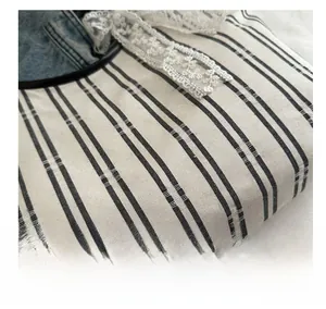 Detail shot of striped canvas fabric with elegant white lace trim and fine textures