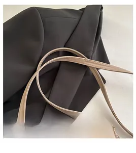Macro detail of beige faux leather bag strap with precise tonal stitching for a clean look