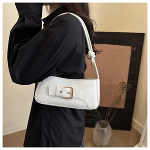 Detail of white rectangular shoulder bag with metal buckle and knotted rope strap