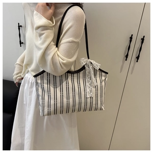 Detail of canvas tote with vintage stripes and delicate white lace bow decoration