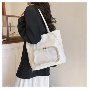 Dettaglio della grande borsa tote bianca con tasca frontale trasparente per accessori