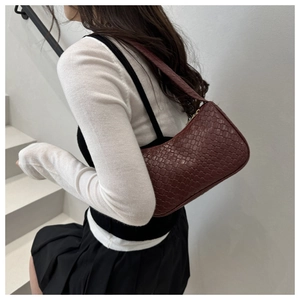 Close-up of deep red woven texture on a stylish minimalist crescent shoulder bag
