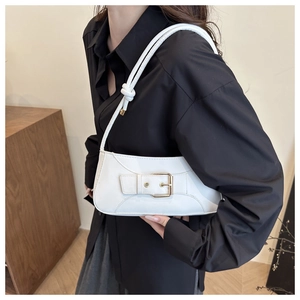 Detail of white glossy leather shoulder bag with knotted strap and gold buckle