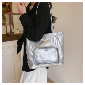 Dettaglio della borsa tote argento metallizzato con tasca frontale in PVC trasparente e zip