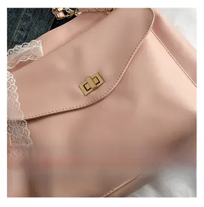Gros plan d'un sac à bandoulière rose en similicuir avec dentelle et fermoir doré