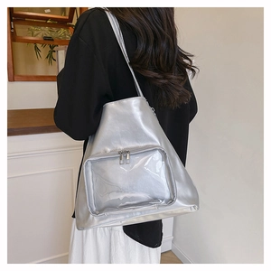 Dettaglio della borsa tote argento metallizzato con tasca frontale in PVC trasparente zip