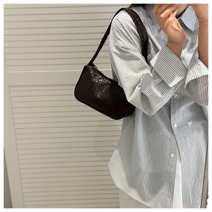 Close-up of brown woven hobo bag showing intricate texture and minimalist shoulder carry style