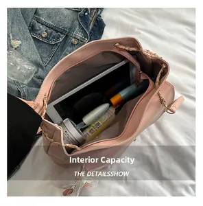 Vue intérieure d'un sac rose matelassé avec chaîne montrant la capacité pour une tablette